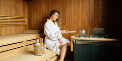 Młoda kobieta w białym szlafroku w saunie
